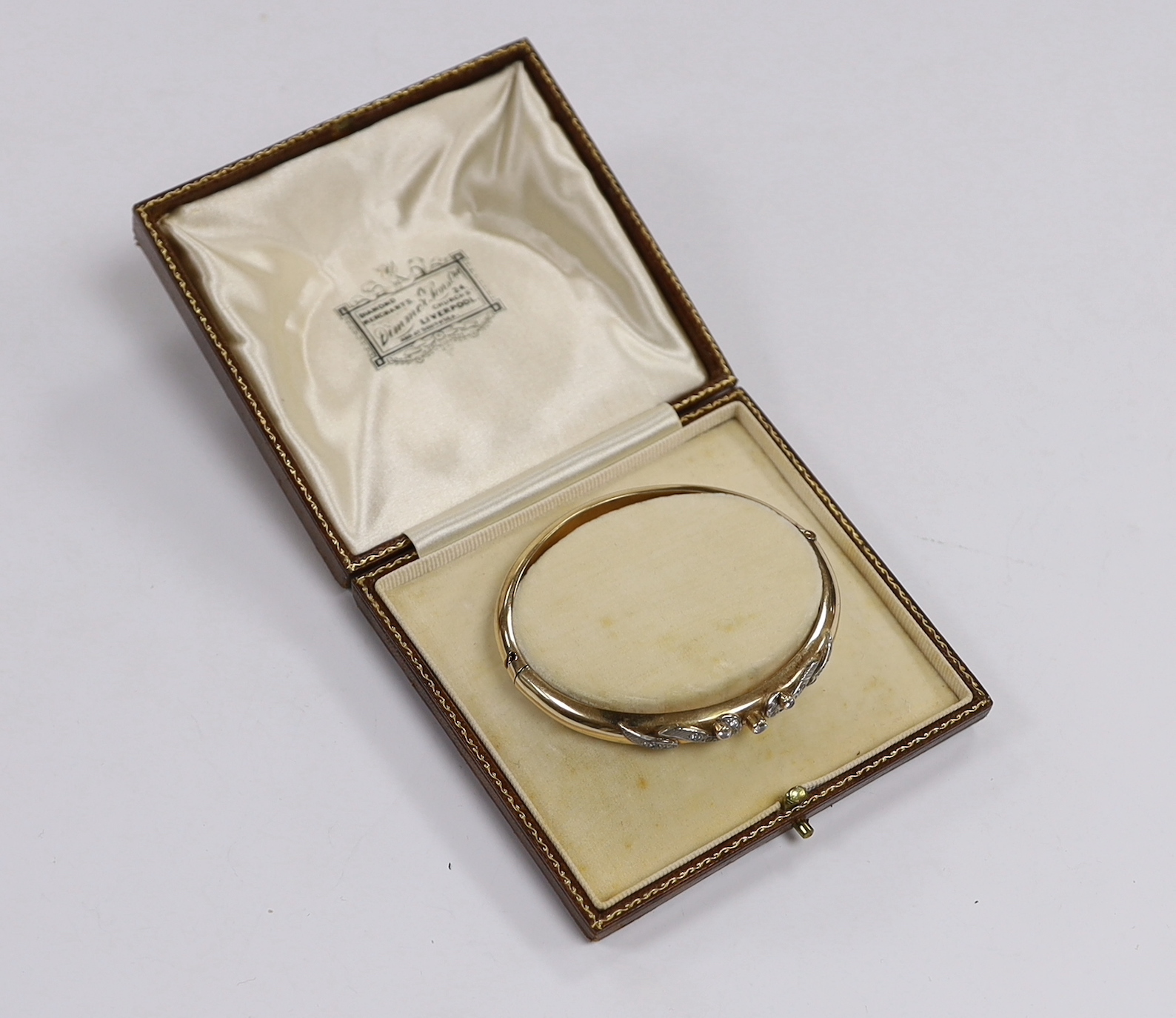 A 585 yellow metal and simulated diamond set hinged bangle, gross weight 20 grams.